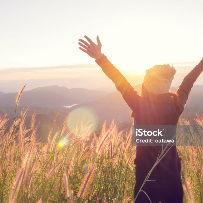 Person Raising Arms in Field